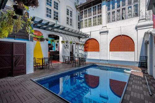 a swimming pool in the courtyard of a building at Koder House in Cochin