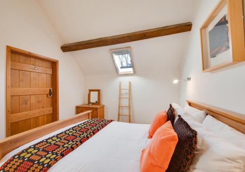 a bedroom with a bed and a wooden door at Dowlod y Gelli in Trawsfynydd