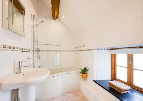 a white bathroom with a sink and a tub at Dowlod y Gelli in Trawsfynydd