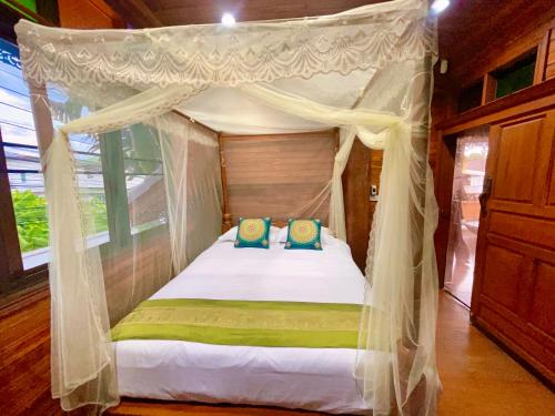 um quarto com uma cama de dossel e 2 almofadas em 泰小院儿（99 Friend’s house Lanna ) em Chiang Mai