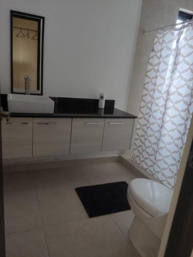 a bathroom with a sink and a toilet and a mirror at Casa entera de lujo Playa del Carmen in Playa del Carmen
