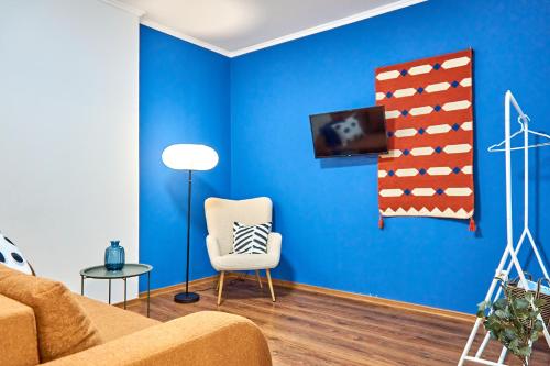 a blue living room with a couch and a chair at Яскраві сучасні Апартаменти для молодих та активних in Mukacheve