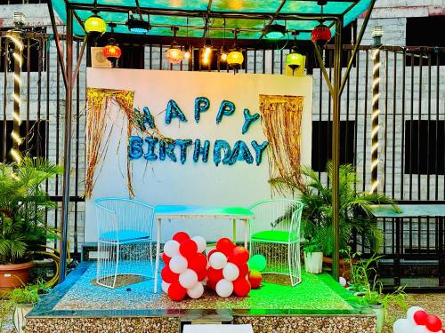 a birthday cake with balloons and a happy birthday sign at Hotel Bhagwati INN Udaipur in Udaipur