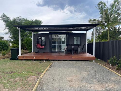 a house with a deck with a swing at Country Tracks in Willowbank