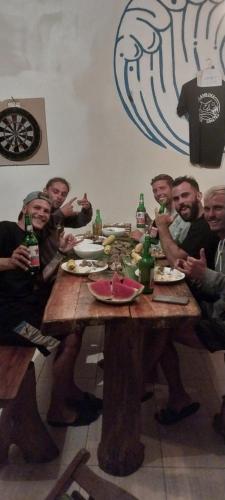 a group of men sitting around a table drinking beer at Kambuna Bungalow in Krui