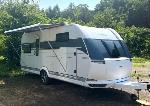 una caravana blanca estacionada en un campo en キャンパーズエリア恵庭 TCS Village, en Eniwa