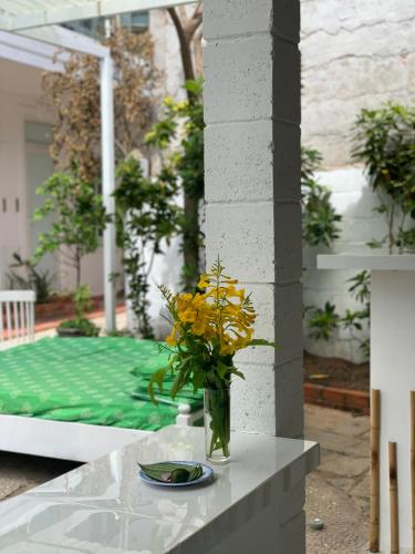 a vase with yellow flowers sitting on a table at A L Y S S A Seaside Muine in Mui Ne