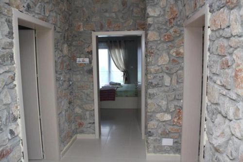 a room with a stone wall with two doors at Hotel Villa Stone Dream Bar Restaurant in Pogradec