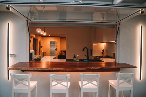 a room with a table and four white chairs at La Plage - A Cosy Cottage in Phillip Island in Cowes