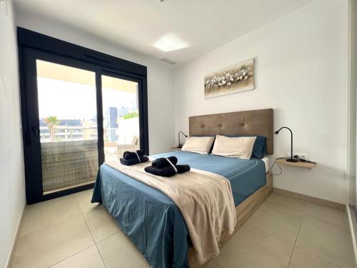 a bedroom with a bed and a large window at Flamenca Village apartment - close to the beach and La Zenia Boulevard in Orihuela