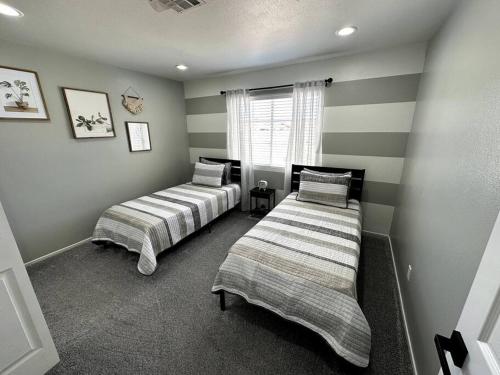 two beds in a room with striped walls at Beautiful Cozy Home in Las Vegas