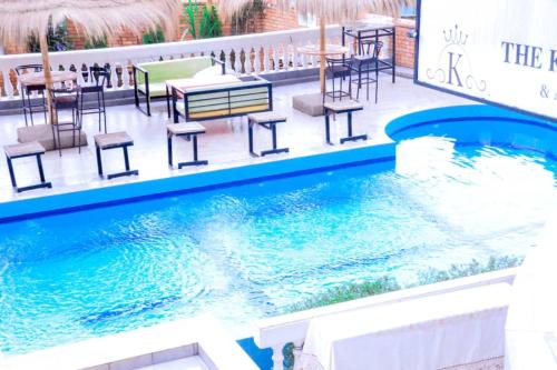 a swimming pool with tables and chairs next to a restaurant at The Keza Hotel and Apartments in Kigali