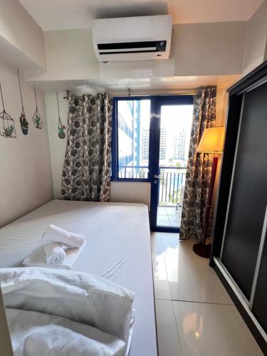 a bedroom with a white bed and a window at Sea Residences Mall of Asia by Jermel in Manila
