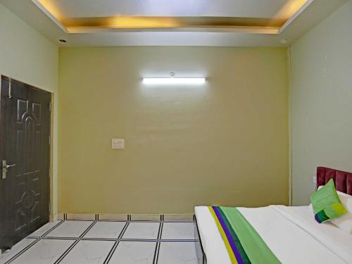 een kamer met een bed en een muur met een deur bij OYO Hotel Expo View Stay in Noida