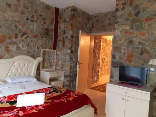 een slaapkamer met een bed en een tv op een aanrecht bij Hotel Villa Stone Dream Bar Restaurant in Pogradec
