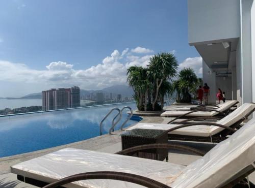 a row of lounge chairs on a hotel swimming pool at Scenia Bay Residence Nha Trang in Nha Trang
