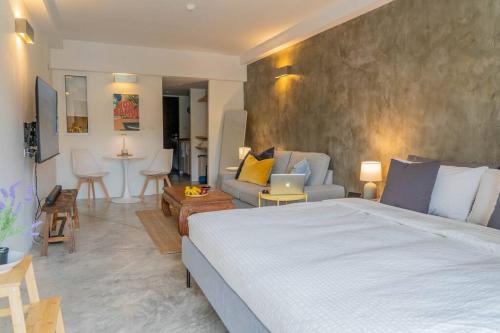 a bedroom with a large bed and a living room at [NEW] Cozy Modern Studio with Pool & Gym in Koh Samui 