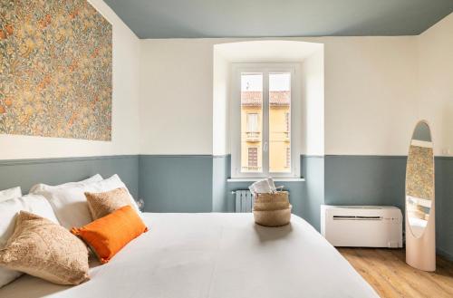 a bedroom with a large white bed and a window at Ripa Apartments Milano - Vigevano in Milan