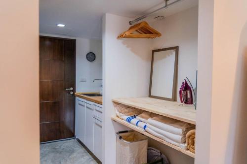 een badkamer met een aanrecht met een spiegel en een wastafel bij [NEW] Cozy Modern Studio with Pool & Gym in Koh Samui 