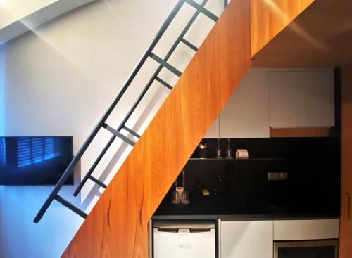 a wooden staircase in a room with a kitchen at Wanderlust, The Unlimited Collection managed by The Ascott Limited in Singapore