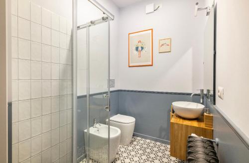 y baño con ducha, aseo y lavamanos. en Ripa Apartments Milano - Vigevano, en Milán