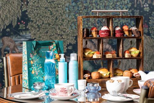 a table with plates and cups and a shelf of food at Scotland's Spa Hotel in Pitlochry