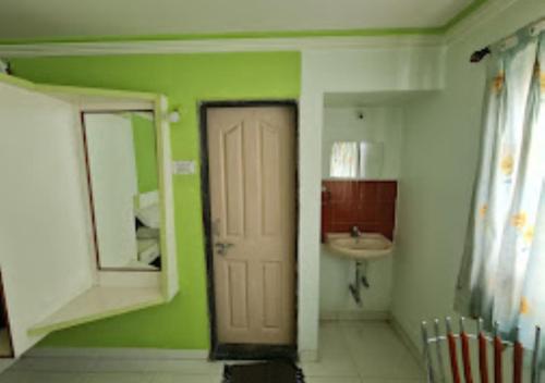 a bathroom with a door and a sink and a mirror at Hotel Udayshree Palace Latur in Latur