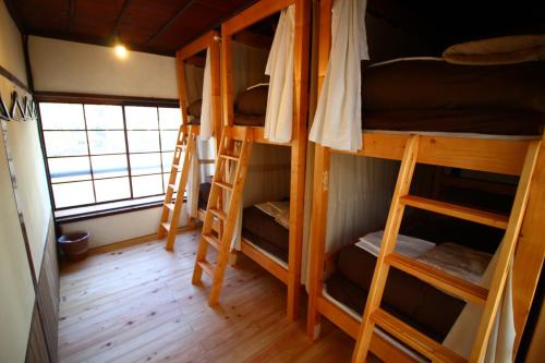 a room with four bunk beds and a window at きよかわゲストハウス in Okutama