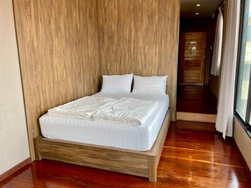 a bed with white sheets and pillows in a room at Baan Keang Chon Ayutthaya บ้านเคียงชล อยุธยา in Phra Nakhon Si Ayutthaya