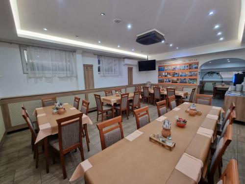 a restaurant with tables and chairs in a room at Heléna Hotel & SPA in Levél