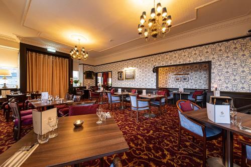 a restaurant with tables and chairs and a bar at Scotland's Spa Hotel in Pitlochry