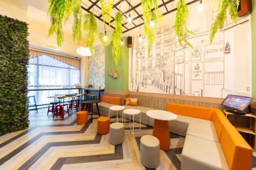 un restaurante con mesas y sillas naranjas y un mural en 三木森sleep Inn 站前館 en Tainan