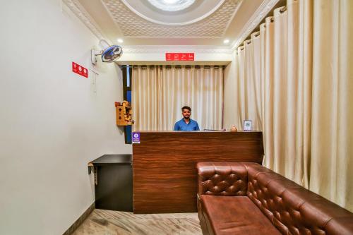 un homme debout derrière un bar dans une salle d'attente dans l'établissement OYO Hotel Tirupati Residency, à Kota