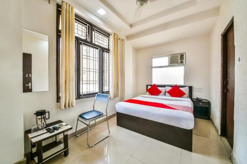 1 dormitorio con 1 cama y 1 silla en una habitación en OYO Hotel Tirupati Residency, en Kota