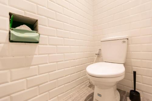 a bathroom with a toilet in a white brick wall at Tainan Little Day in Tainan