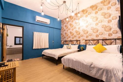 台南的住宿－小日子文創旅店 ，蓝色墙壁客房的两张床