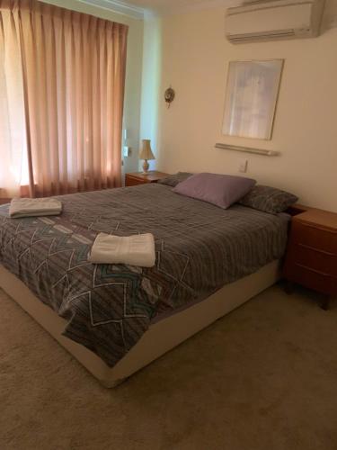 a bedroom with a large bed with two towels on it at Hamersley Hacienda in Perth
