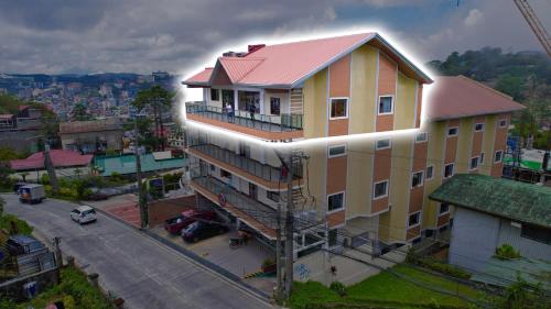 un gran edificio amarillo con techo rojo en RNJ Hotel, en Baguio