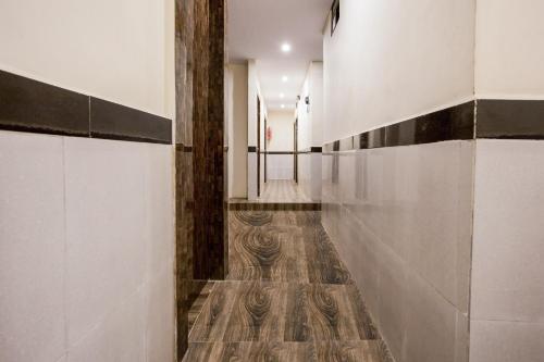 a hallway with white walls and a wooden floor at OYO Flagship Hotel Subodaya in Nerul