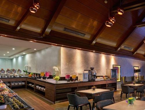 um restaurante com mesas e cadeiras e um balcão em Sama-Sama Express KLIA Terminal 1 - Airside Transit Hotel em Sepang