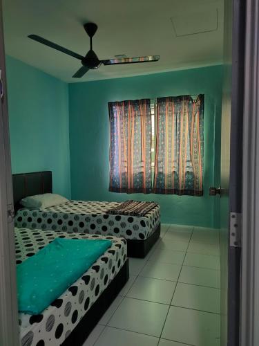 a bedroom with two beds and a ceiling fan at Prima Homestay Ranau in Ranau