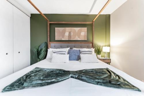 een slaapkamer met een bed met een groene muur bij Downtownkingrooftopfitnesstop Flr City View in Oak Park