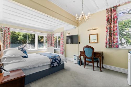 a bedroom with a bed and a desk and a chair at Aachen House in Auckland