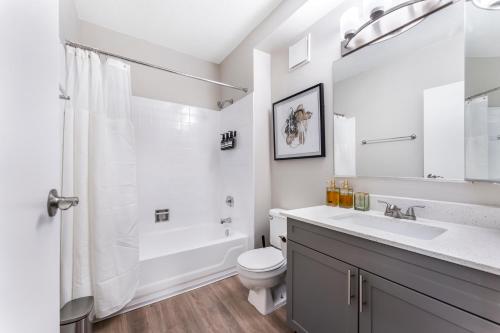 a white bathroom with a sink and a toilet at Downtownkingrooftopfitnesstop Flr City View in Oak Park