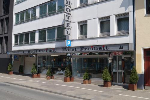 eine Hotelfront mit Topfpflanzen vor einem Gebäude in der Unterkunft Hotel Freiheit in Köln