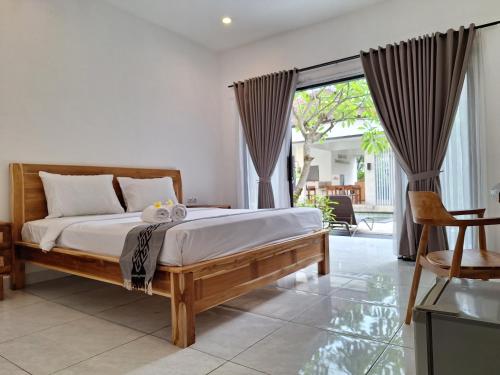 a bedroom with a bed and a large window at Balian Paradise Resort in Selemadeg