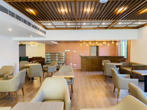 a restaurant with tables and chairs and a bar at Hotel Windy Terrace in Cox's Bazar