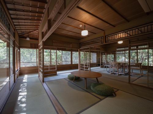 a room with a table and chairs and windows at ThinkStay Mt.(シンクステイ・マウンテン) in Mikagechō