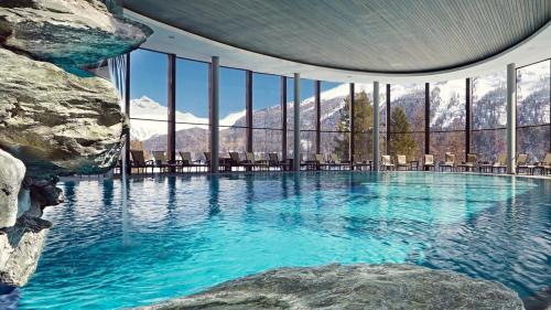 a large swimming pool with mountains in the background at LA GRAA in Piuro