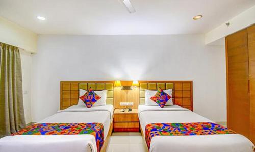 a hotel room with two beds and a desk at FabHotel Prime Indeedcare Hotel & Resorts - Nr Kolkata Airport in Jojera